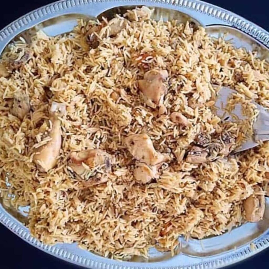 fragrant rice cooked with tender chicken pieces, caramelized onions, and garnished with fresh coriander.