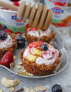 Granola cups filled with creamy Greek yogurt, topped with fresh blueberries and raspberries.