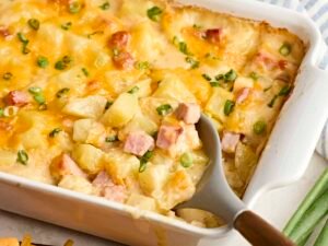 Creamy ham and potato casserole baked golden in a white casserole dish