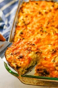 Baked breakfast casserole with golden hash browns and fluffy eggs in a white dish