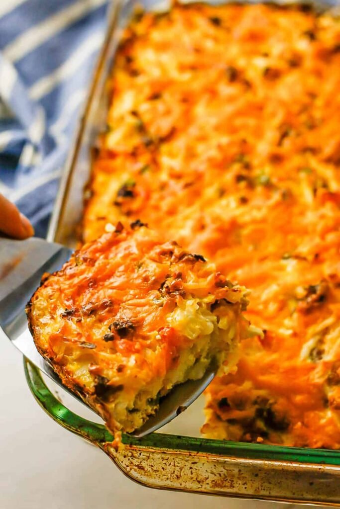 Baked breakfast casserole with golden hash browns and fluffy eggs in a white dish