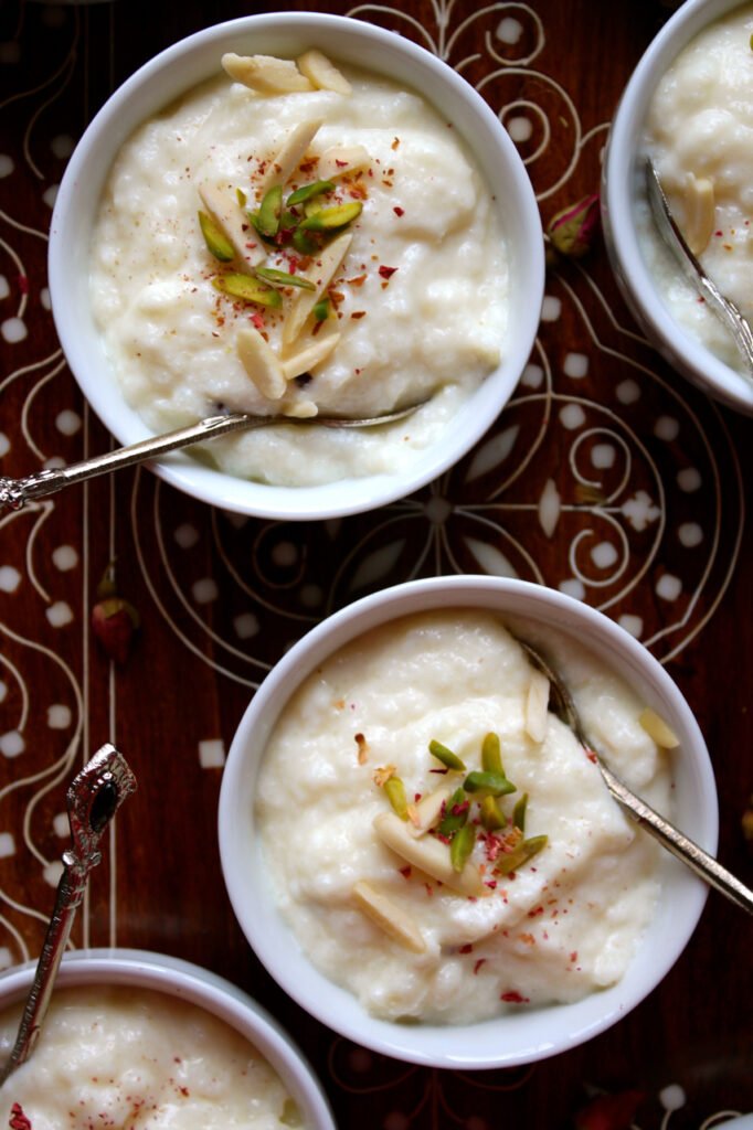 Creamy kheer served in a white ceramic bowl, garnished with chopped pistachios, highlighting its rich, velvety texture