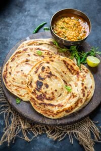  Crispy golden Lachha Paratha stacked with visible flaky layers