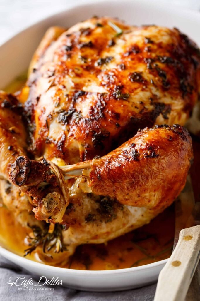 Close‑up of a garlic‑herb butter roast chicken, showcasing crispy, richly seasoned skin with visible herb flecks and a caramelized sheen. Alt‑text: “Crispy roast chicken breast glistening with garlic‑herb butter, the skin crackled and dotted with fresh herbs.”