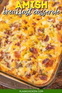 Cheesy Amish breakfast casserole in a white baking dish with golden crust and herbs on top
