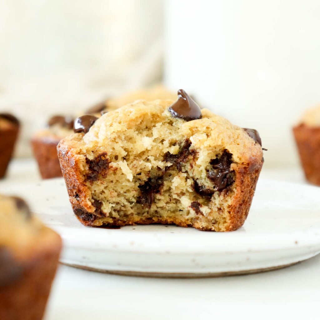 “Close-up of a moist banana chocolate chip muffin with melted chocolate chips inside.