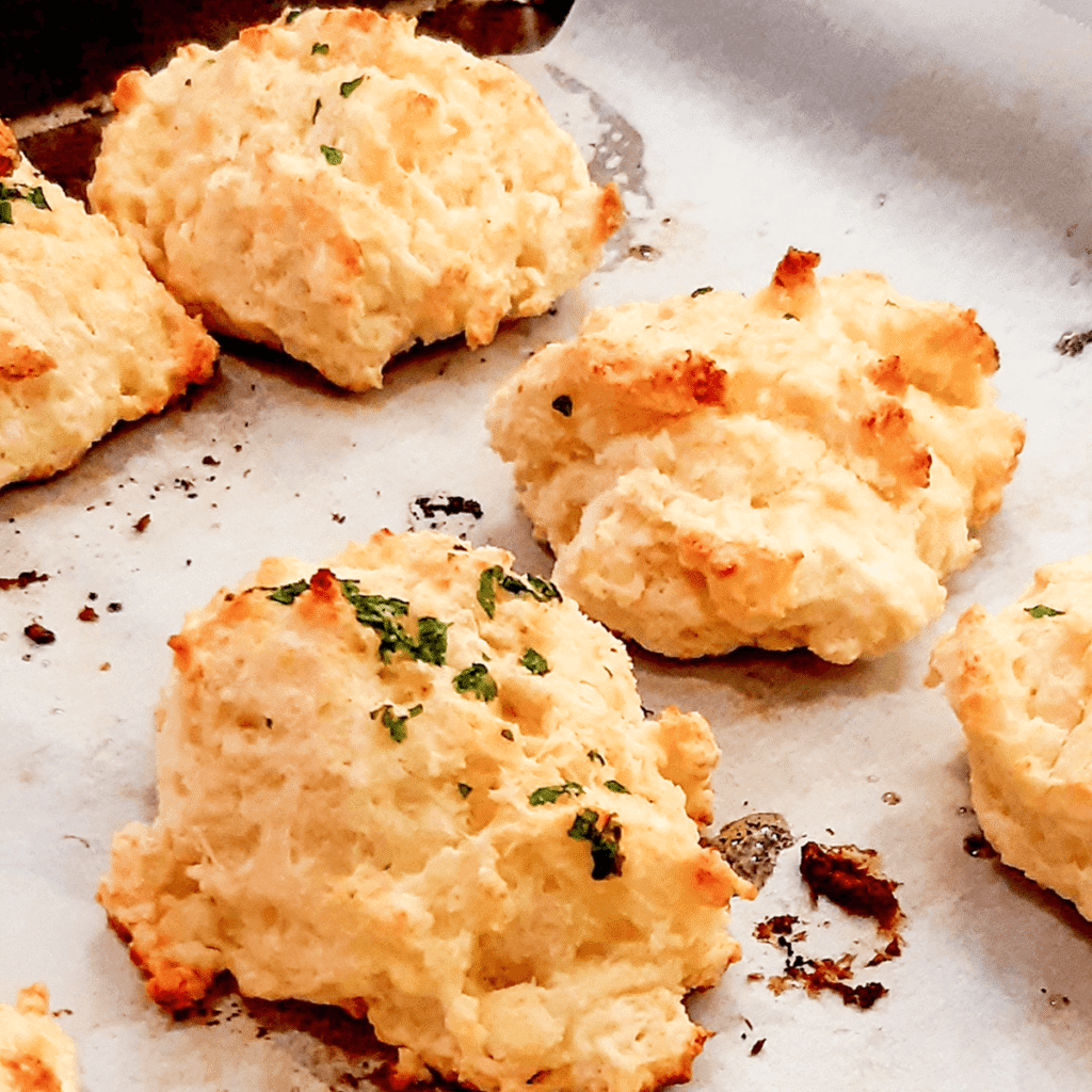 Square cheese‑savory tea biscuits on parchment – a savory twist on the classic. “Savory square tea biscuits with cheese on parchment paper.