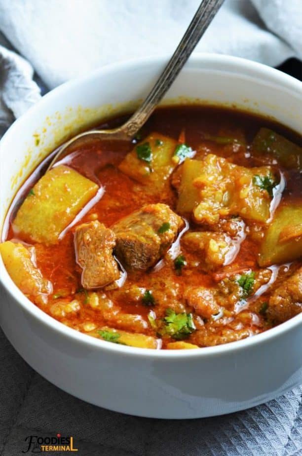 Instant-Pot style lauki gosht: chunks of bottle gourd and mutton in spicy curry, served in a white bowl with steam rising