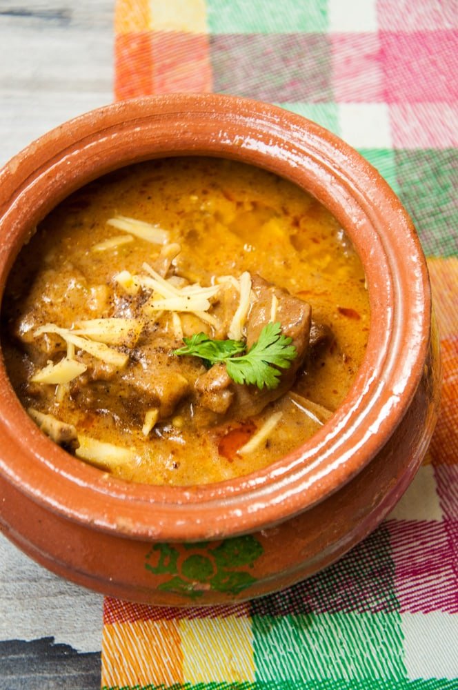 “Traditional kunna served in a clay pot with naan