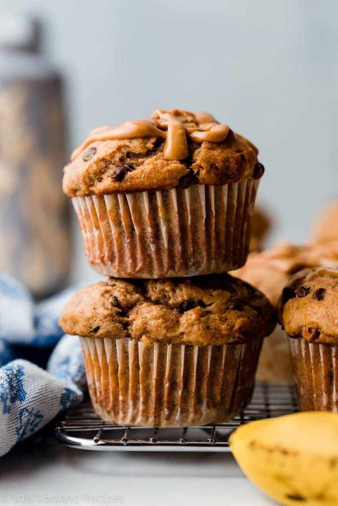 “Creamy peanut butter banana muffins arranged on a plate, topped with banana slices”