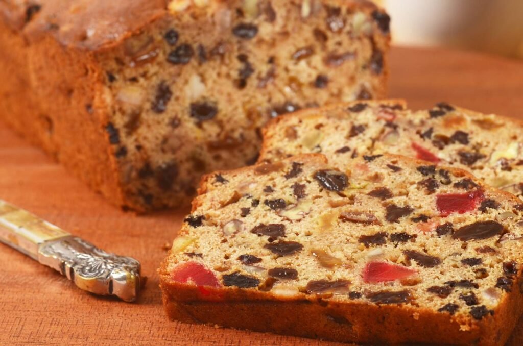 A close‑up of a traditional tea fruit cake loaf, showcasing a dense texture dotted with candied peel and nuts—capturing its rich, spiced character.