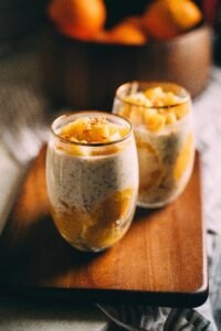 A vibrant glass jar of mango chia pudding, layered with creamy mango puree, chia seeds, and fresh mango chunks — a healthy and refreshing summer dessert.