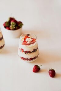  Layered strawberry yogurt parfait in a glass jar topped with granola and honey – a refreshing summer treat.